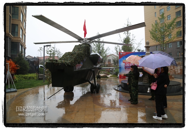 小區(qū)突然出現(xiàn)“飛機坦克”，其中殲15艦載戰(zhàn)斗機一架、99式主戰(zhàn)坦克一輛、武直-10武裝直升機一架，吸引了眾多市民雨中圍觀、合影。